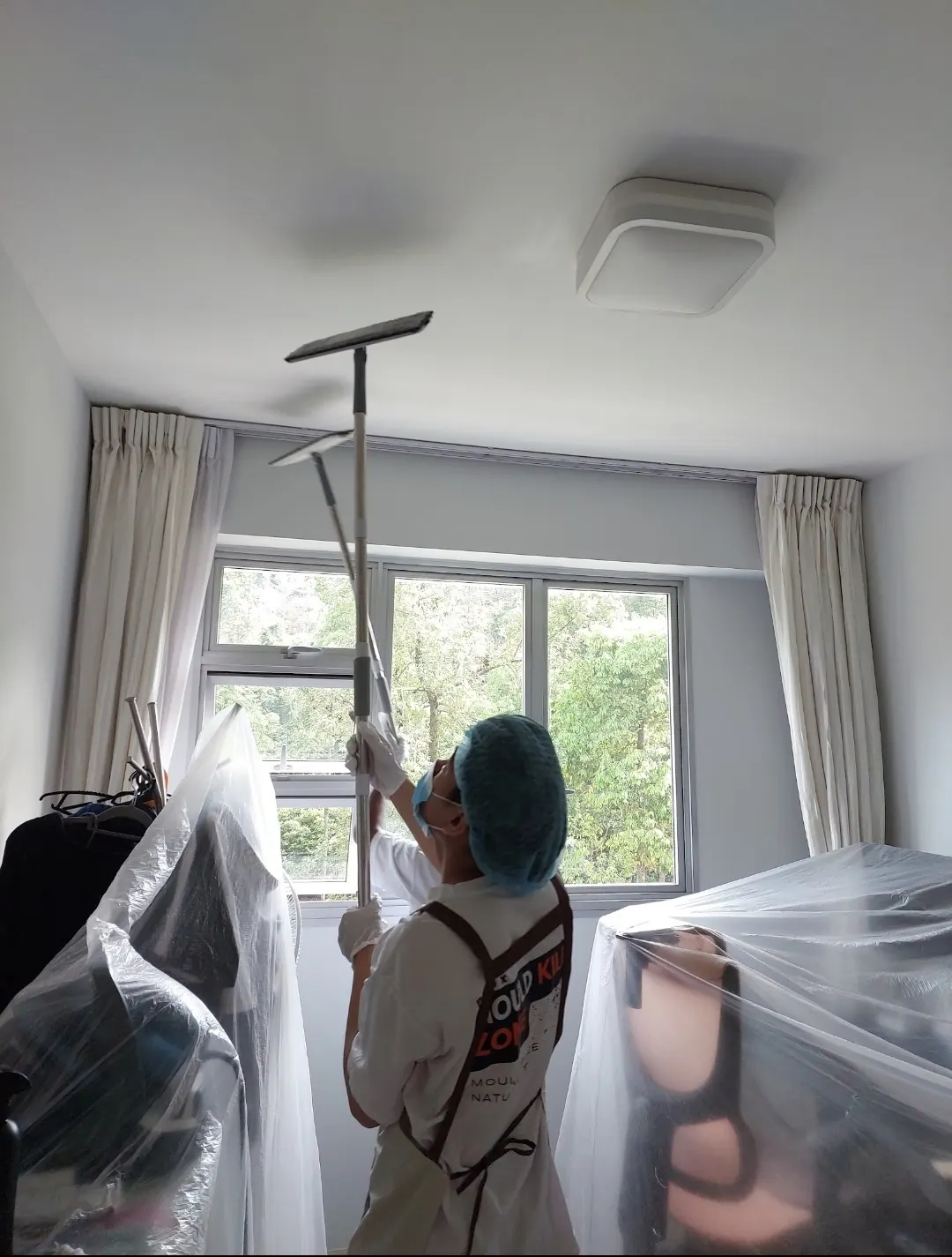 Pico X Health technician uses professional ceiling sander for mould removal with protective floor sheeting - Singapore condo